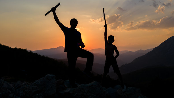 小男孩的成功，他和他的父亲一起攀岩运动，他为登顶而奋斗图片下载