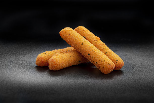 黑色背景上的奶酪棒图片下载