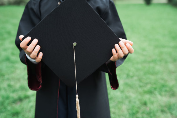 回到小学的概念。小女孩上一年级。毕业仪式。黑色长袍，带流苏的学术帽。与家长，老师在公园，院子聚会。最后一天，年底图片下载
