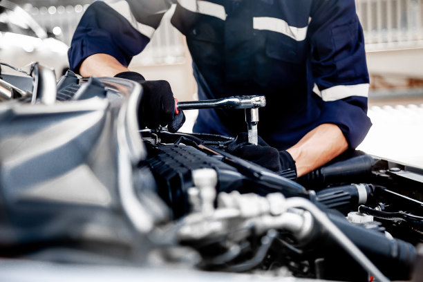 汽车保养维修，近距离手技师使用扳手维修更换零部件汽车发动机问题和保险服务支持。图片下载