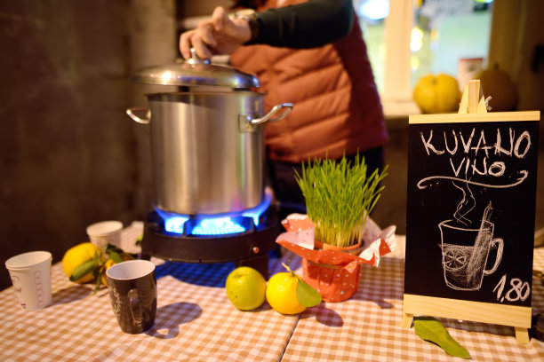 在欧洲圣诞市场准备和销售热红酒。圣诞假期在科托尔集市，黑山。牌子上写着“热红酒”。图片下载