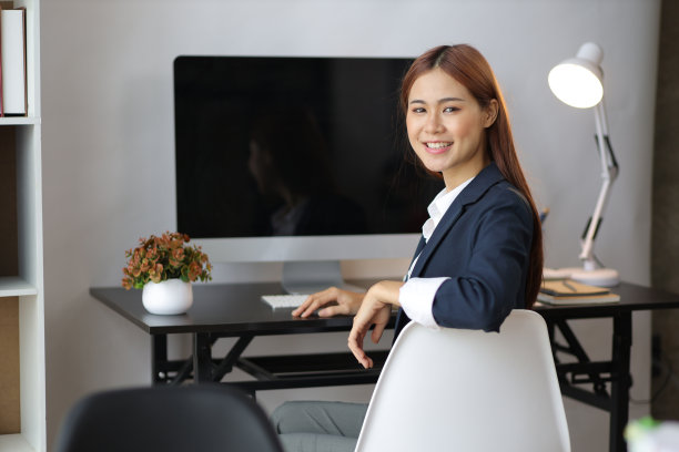 肖像有吸引力的美丽的亚洲商业女性工作在电脑上的书桌在家庭办公室。图片下载