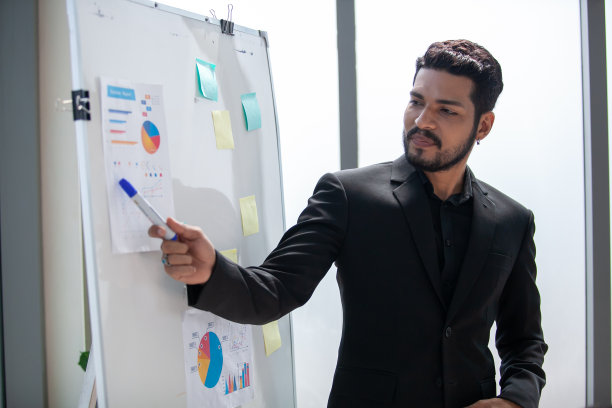 亚洲业务团队男女同事在工作中交谈分享想法与图表在董事会，快乐的年轻演示同事在董事会一起工作。图片下载