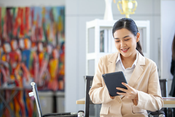亚洲美丽的商业女性在办公室工作的肖像，美丽的女性在工作场所使用触摸板微笑。图片下载