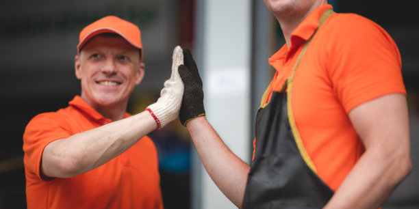 高级和年轻的男性汽车机械师和同事在车库工作时击掌以示团队合作良好图片下载