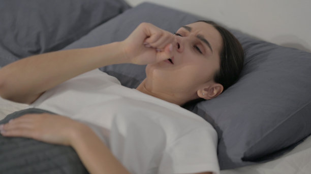 西班牙妇女在床上睡觉时咳嗽图片下载