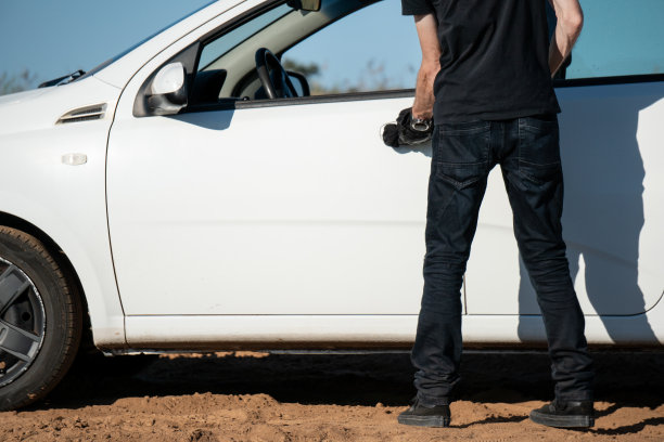 一个人打开一辆白色轿车的门图片下载