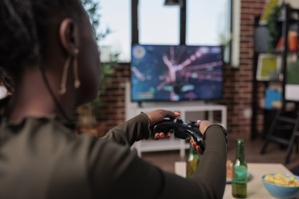 非裔美国妇女手持操纵杆玩射击视频游戏图片下载