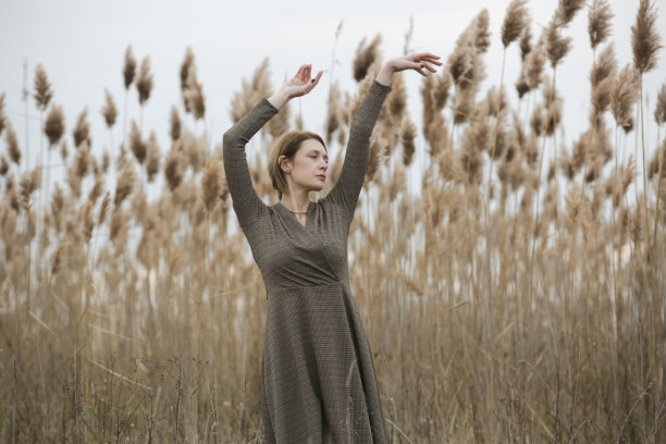 时尚户外肖像的年轻女子在秋天棕色长袖连衣裙。图片下载