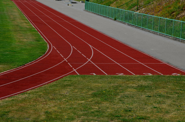 运动员的障碍训练，在学校院子里的床垫上跳高。椭圆形跑道:有标记的跑道上标有五名参赛者的号码图片下载