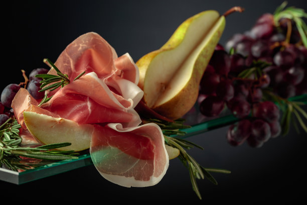 熏火腿配迷迭香，梨和葡萄。图片下载