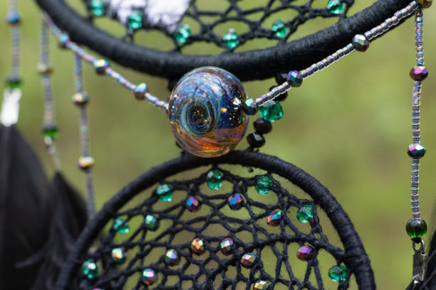 手工捕梦网，羽毛，线和珠绳悬挂图片下载