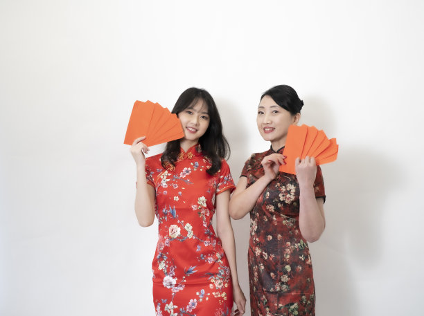 快乐的亚洲年轻女子和母亲为庆祝中国新年展示财富图片下载