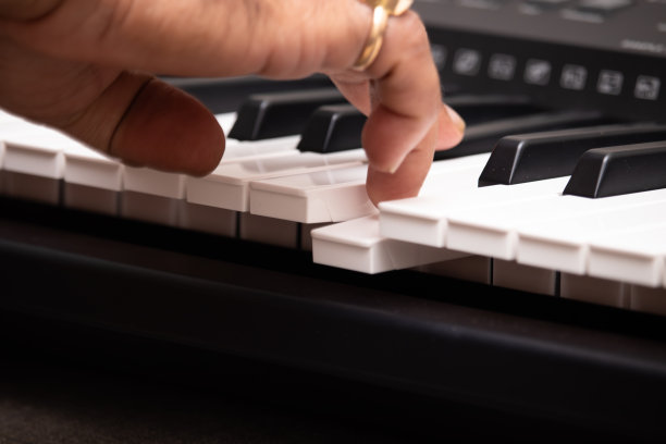 手戴祖母绿天然帕纳和蓝色蓝宝石尼兰宝石在钢琴或键盘上弹奏音符。音乐培训或指导，现场音乐会，娱乐，休闲爱好概念图片下载