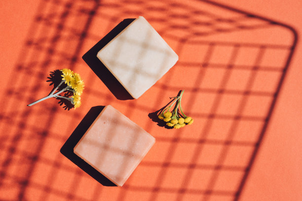 现代的平铺组成手工有机肥皂条由天然成分，花和香草在橙色背景。在家自制天然纯素草本肥皂图片下载