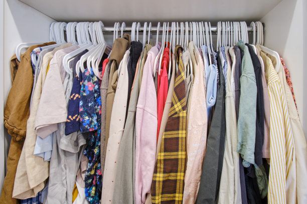 开放式的衣架上挂着女性的衣服，女性的衣服和衬衫挂在衣柜里图片下载