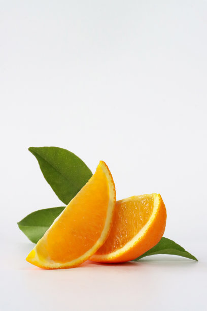 特写图像的柑橘水果片与叶子，塞维利亚橙子楔形，白色背景，重点在前景，复制空间图片下载
