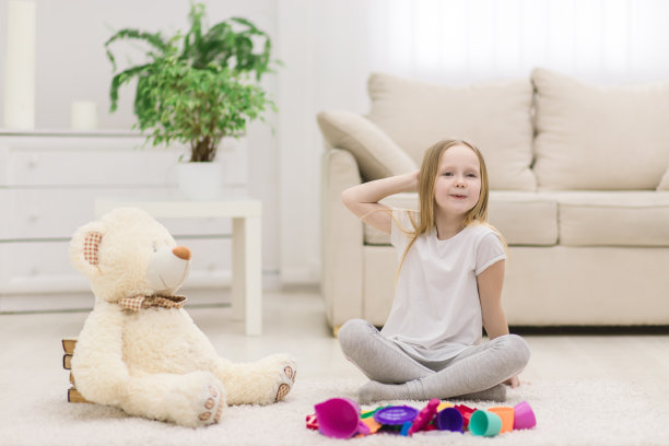 小女孩和她的玩具摆姿势拍照的照片。图片下载