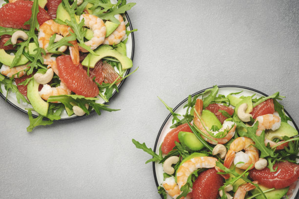 健康新鲜的沙拉配虾，牛油果，柚子，芝麻菜和腰果。灰色石材厨房餐桌背景，俯视图，复制空间图片下载