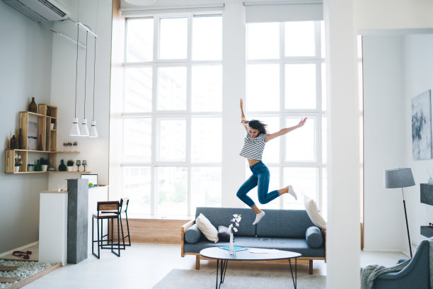 富有表现力的年轻女士在家庆祝成功图片下载