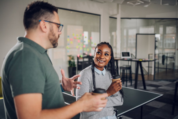 多种族的同事在工作休息时间边喝咖啡边聊天图片下载
