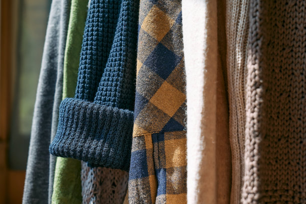 针织毛衣挂在衣架的衣架上。慢时尚。有意识的消费。车库甩卖，再利用衣物，二手和生态消费理念。图片下载