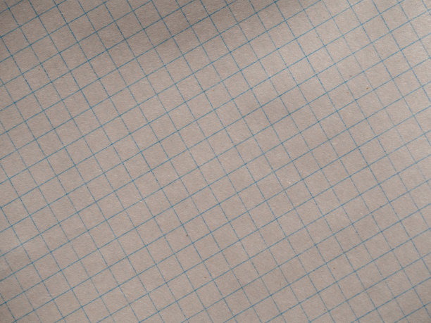 黄色的笔记本纸放在笼子里，有纹理的纸背景。在对角线笼子里的笔记本纸的背景或在网格特写里的纸的背景。粗糙的表面有纤维素纤维图片下载