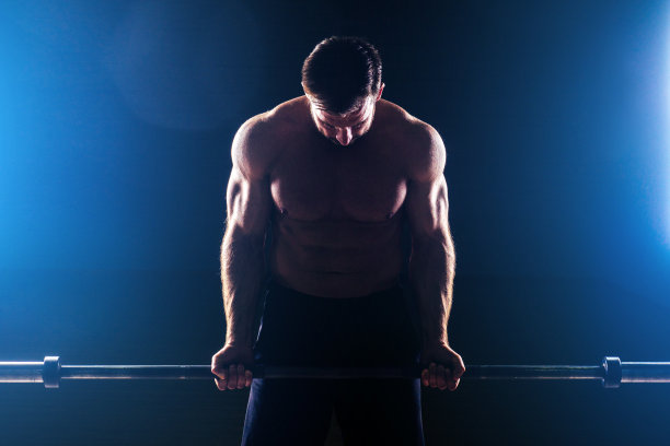 肌肉健身男子古董雕像完美的肌肉六块腹肌和裸露的胸部健美运动员阿波罗模型健美运动员使锻炼杠铃二头肌在健身房的黑色背景图片下载