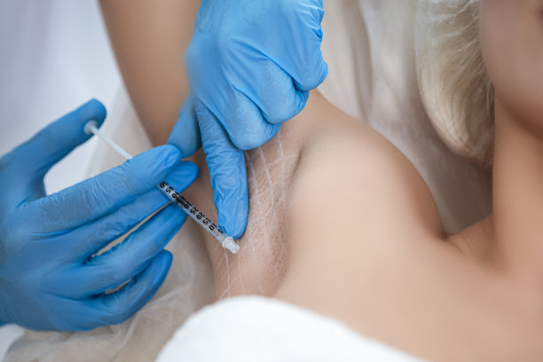 年轻白人妇女在美容院接受腋窝注射的特写图片下载