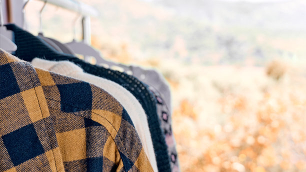 针织毛衣挂在衣架的衣架上。慢时尚。有意识的消费。车库甩卖，再利用衣物，二手和生态消费理念。图片下载