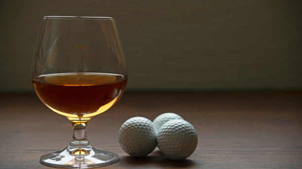 酒杯与高尔夫球在乡村木桌上图片下载