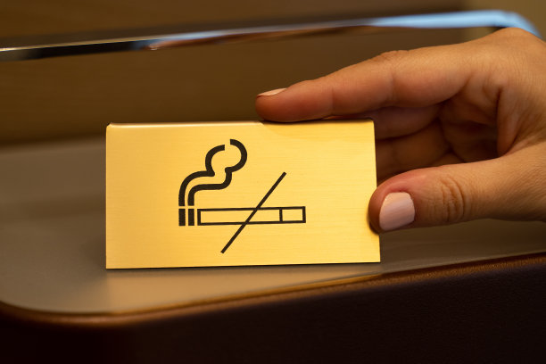 服务员把印有禁止吸烟标志的金盘子放在木架子上图片下载