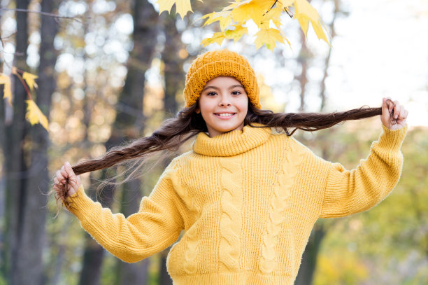 开朗的女孩在秋日穿针织衫，时尚图片下载