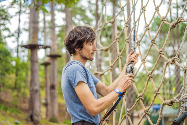 年轻迷人的男子在冒险绳索公园的安全设备图片下载