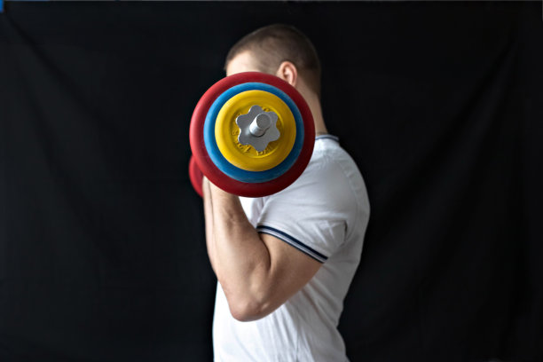 一个强壮，健康，肌肉发达的男人，在家里用杠铃训练。在家健身。图片下载