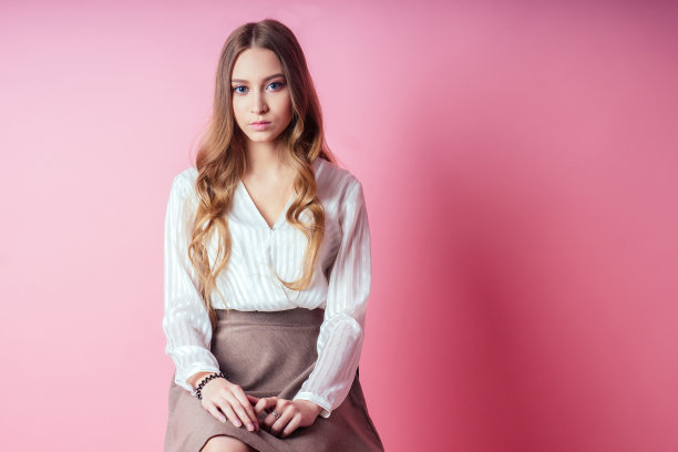 肖像的年轻和美丽的女学生少女在工作室的粉红色背景图片下载