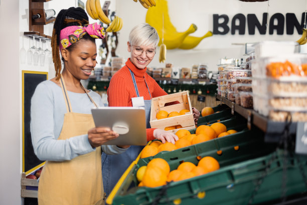 两个年轻的女售货员在水果店合作图片下载
