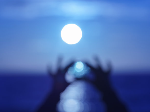 离焦摄影清晰水晶球在海上在人的手中图片下载