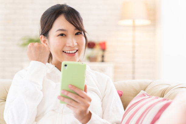 迷人的亚洲女性正在使用智能手机图片下载