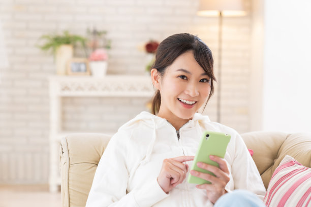 迷人的亚洲女性正在使用智能手机图片下载