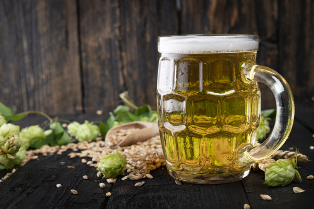 木桌上放着一杯淡啤酒，上面放着泡沫图片下载