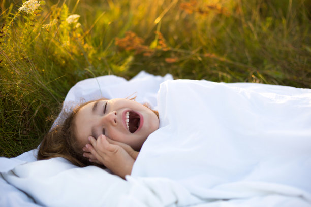 女孩睡在草地的床上，甜甜的懒懒地伸懒腰，打着瞌睡，早上好，空气新鲜。环保、健康睡眠、防蚊、清洁自然、生态、儿童健康图片下载