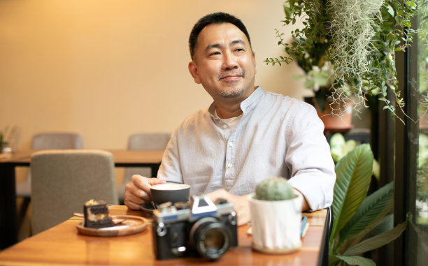 中间快乐微笑的成年人在咖啡馆喝咖啡图片下载