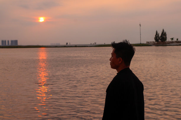 在海滩夕阳下放松的年轻人图片下载