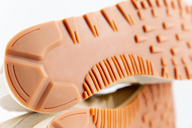 棕色沟槽鞋底运动鞋的一部分在一个白色的背景。图片下载