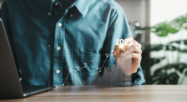 一位商人正在分析一家以数字图形为基础的公司的盈利能力。箭头在2023年升起。商人为长期投资计算财务数据。图片下载