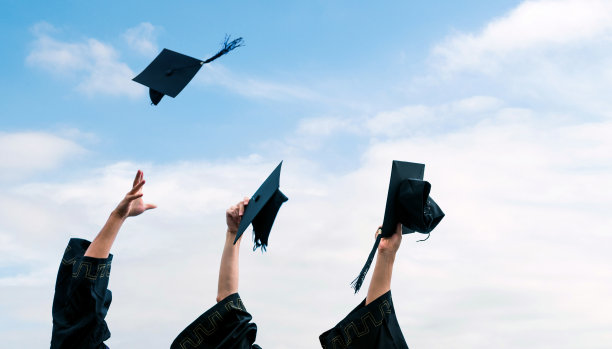 三个毕业生双手向空中扔毕业帽图片下载