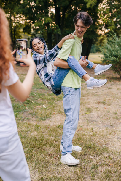 白人女孩用手机录下两个人跳舞的视频并发布在网络应用程序上。社交网络的趋势。受欢迎的应用程序。社交媒体网络。图片下载