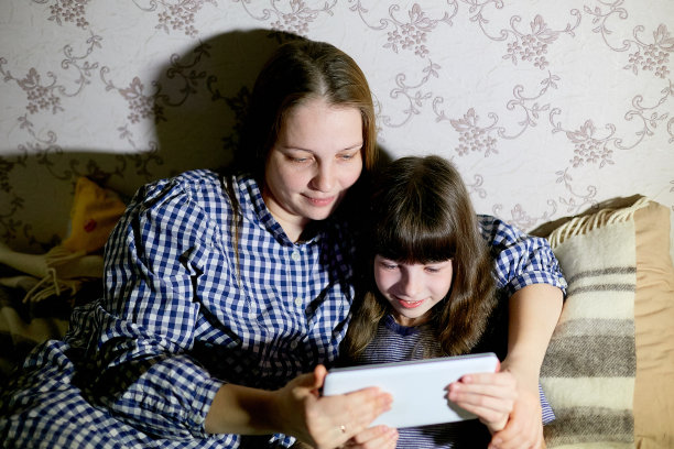 母亲和孩子在家里用平板电脑看动画片和玩耍图片下载