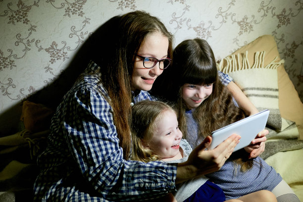 母亲和孩子在家里用平板电脑看动画片和玩耍图片下载